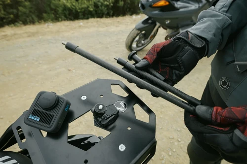 Motocyklista trzyma w rękach zestaw GoPro Carbon Fiber Extension Set