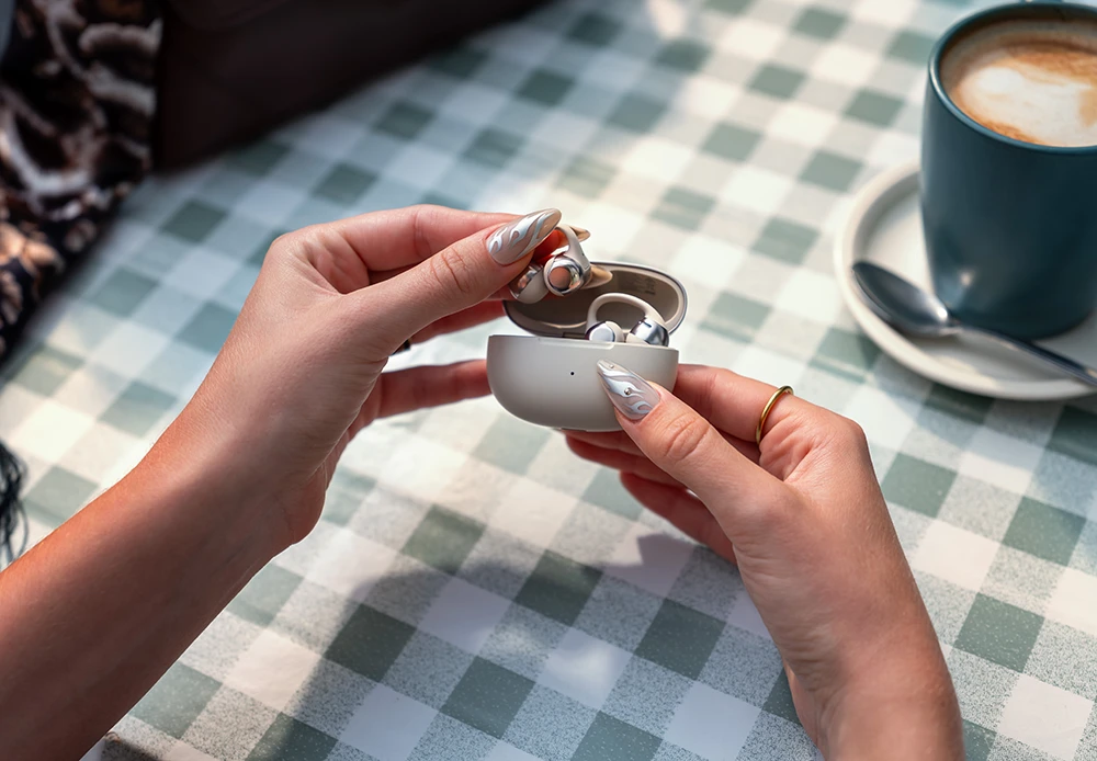 Umieszczanie słuchawek Shokz OpenDots One Grey w etui ładującym